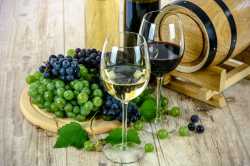 Ein Glas Rotwein & ein Glas Weisswein mit Trauben und einem kleinen Barriquefass