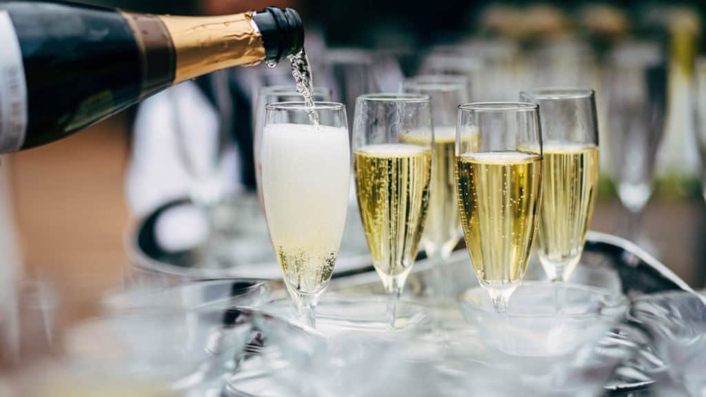 Chardonnay-Trauben neben Glas Champagner – vielseitige Verwendung der Traube