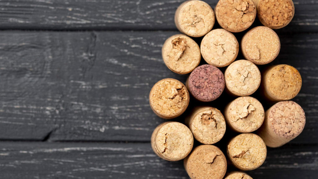 Gruppe von Korken von Dôle Weinflaschen auf dunklem Holzuntergrund