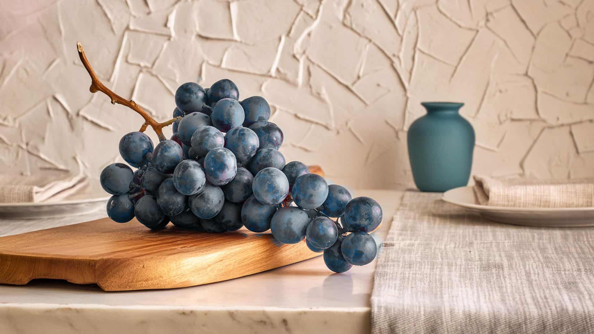 Die Gamaret: Entdecken Sie die Rotwein-Spezialität aus der Schweiz 3 gamaret rotweintrauben auf einem holzteller