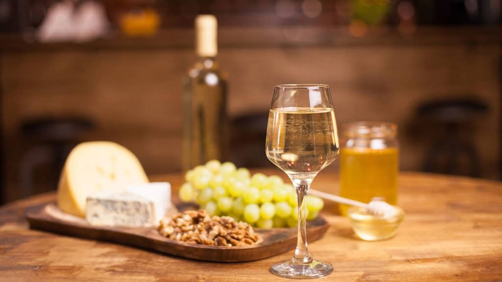 Malvoisie‑Weisswein serviert mit Käse – perfekte Kombination zu Speisen