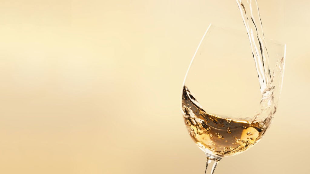 Weisswein wird ins Glas eingeschenkt – frischer Genussmoment