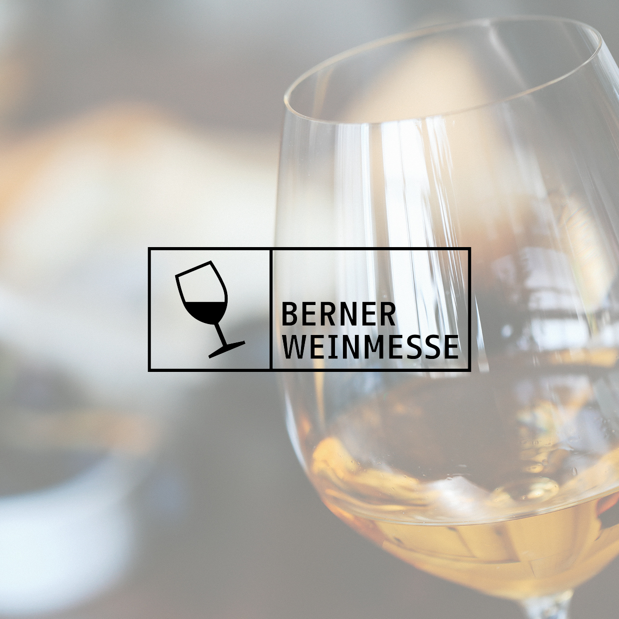 Weinglas mit hellem Wein vor unscharfem Hintergrund und daneben das Logo mit einem schräg stehenden Weinglas und dem Schriftzug 'BERNER WEINMESSE'