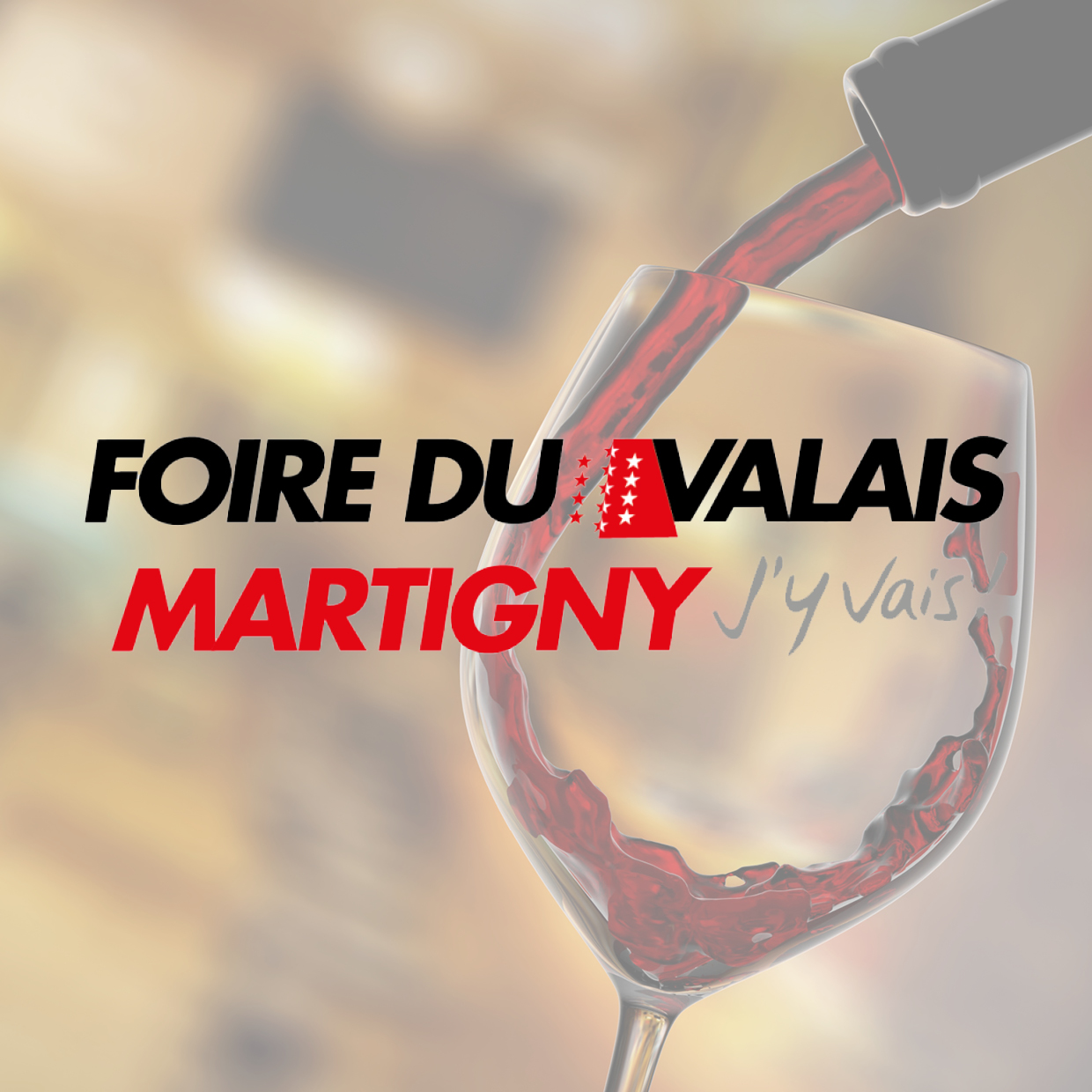 Weinglas, in das Rotwein eingeschenkt wird, mit dem Schriftzug 'FOIRE DU VALAIS MARTIGNY J'y vais'