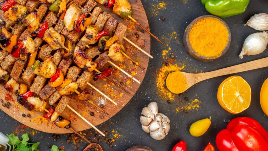 Grillspiesse auf Holzteller als BBQ Gericht