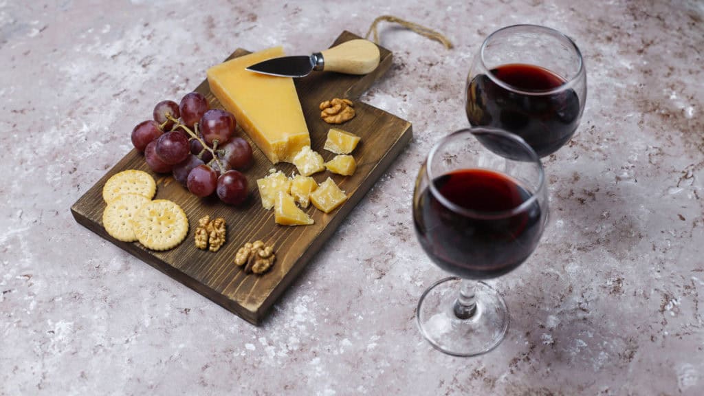 Hartkäse mit Rotweingläsern auf Tisch, Wein & Käse Arrangement