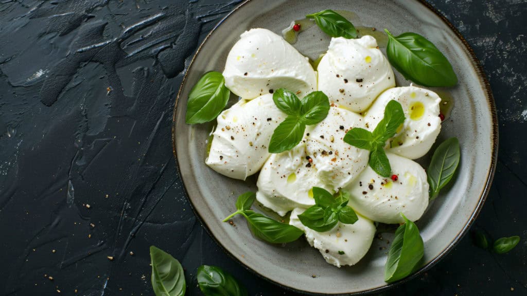 Mozzarella auf Holzbrett, Wein & Käse Präsentation, grüne Kräuter dekoriert