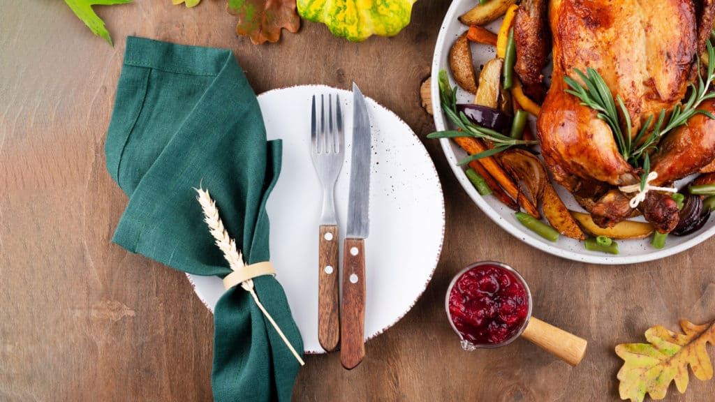 Wein & Wild: Geflügelgericht auf Teller mit Kräutern auf Holztisch