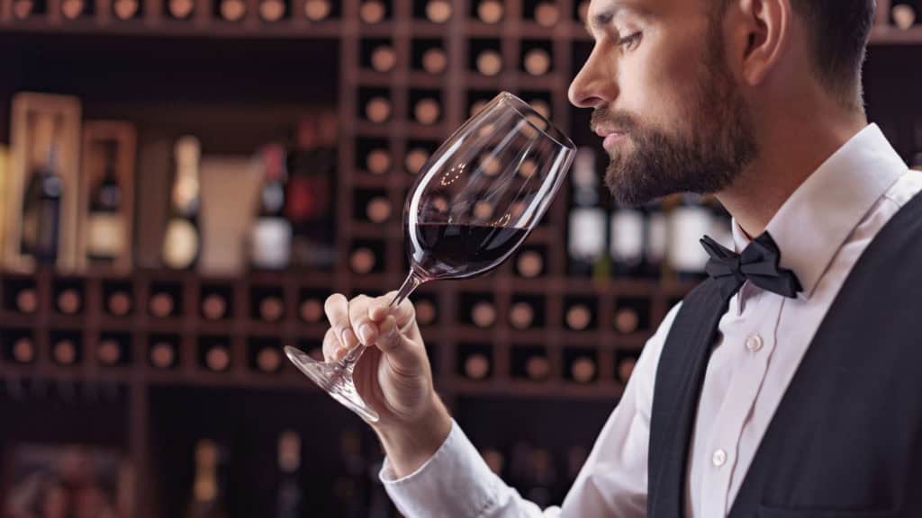 Weinsommelier riecht an Rotweinglas – Degustation und Aromaerkennung