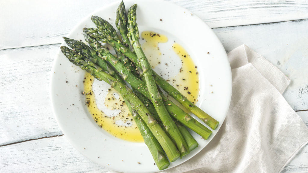 Cooked asparagus on a white plate - ready to serve and enjoy