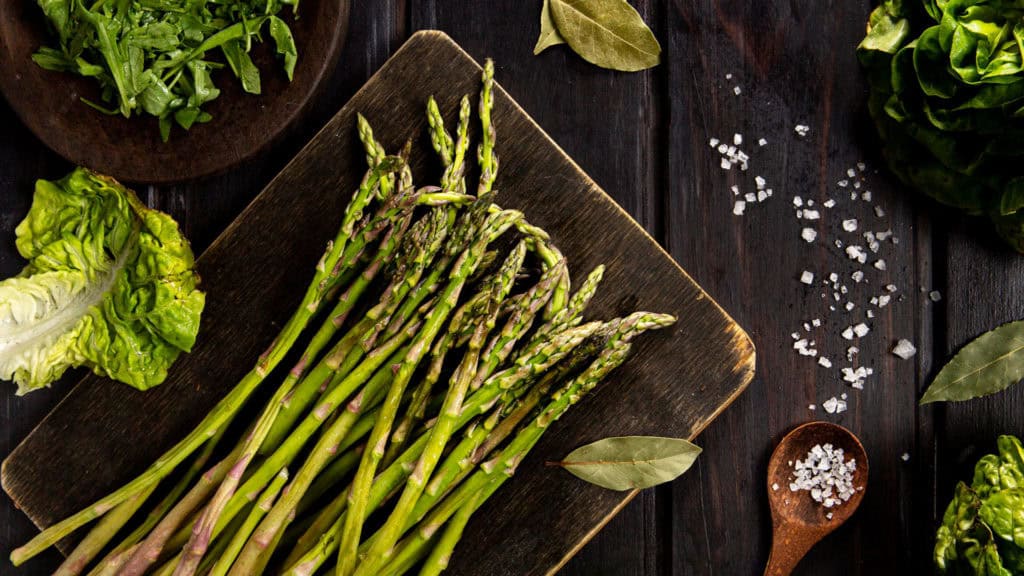 Green asparagus on a wooden board - fresh vegetables to prepare
