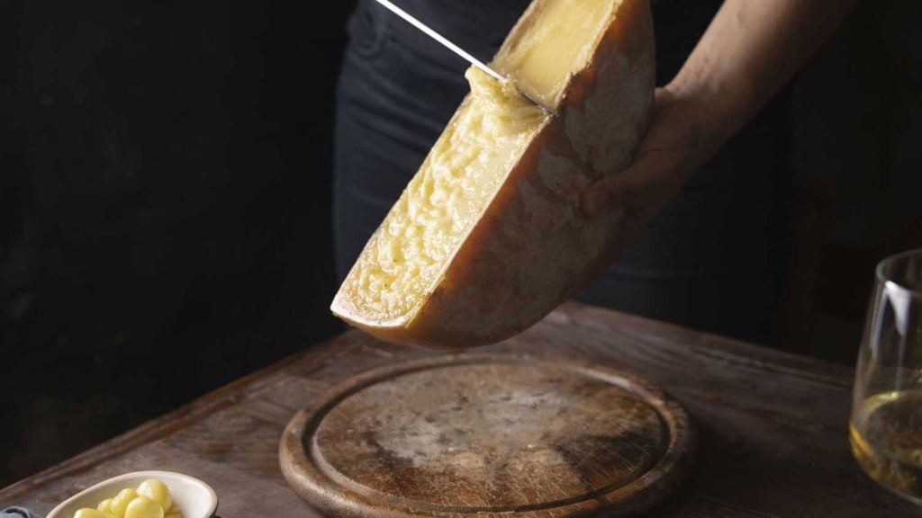 Weisswein mit Raclette auf Holzteller – harmonische Kombination