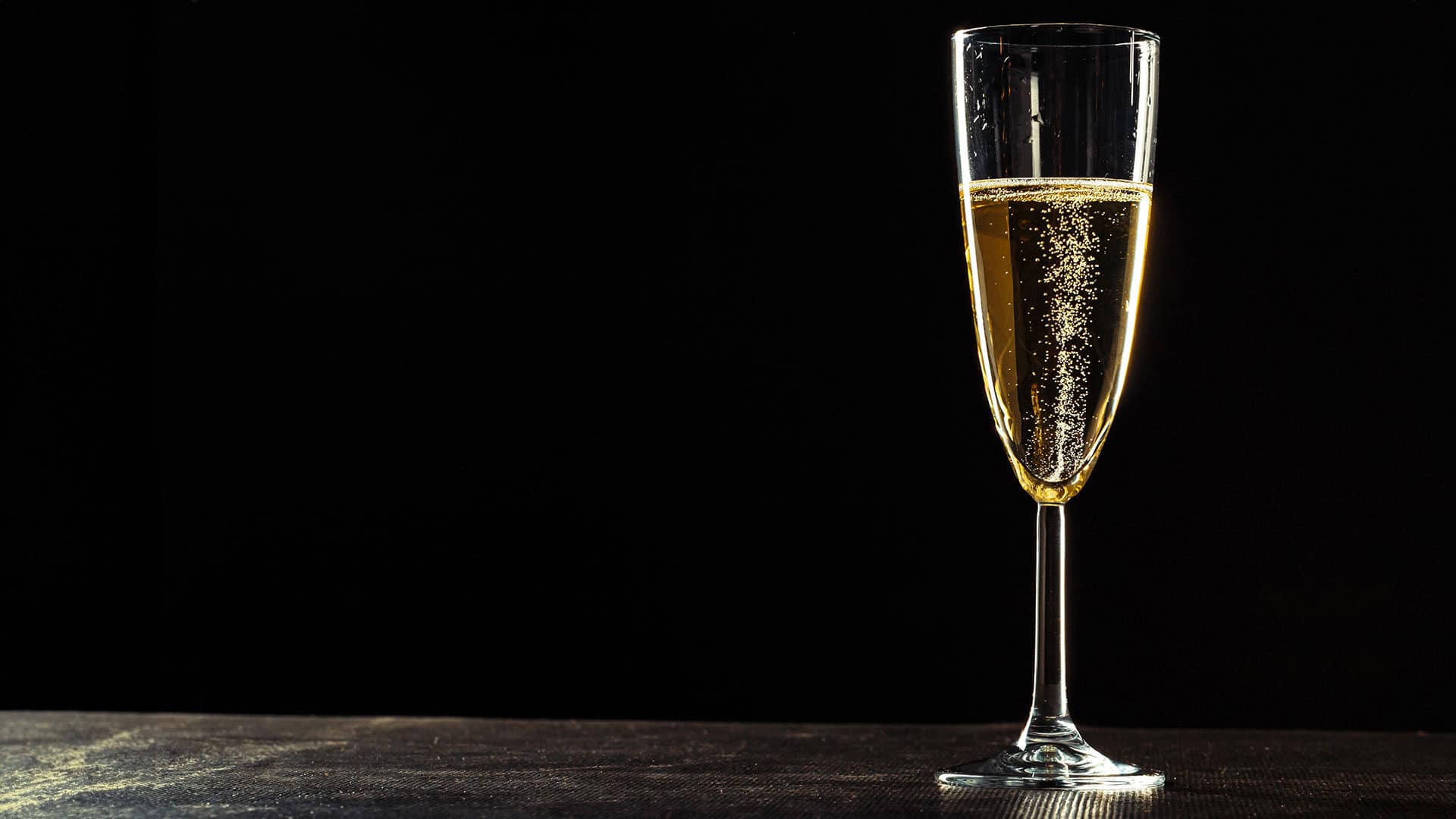 schaumwein champagner glas mit dunklem hintergrund