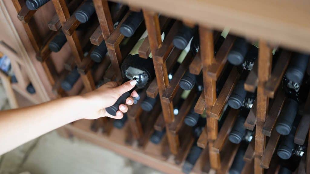 Weinflaschen gelagert zur Vorbereitung fürs Chambrieren in Kellerregal