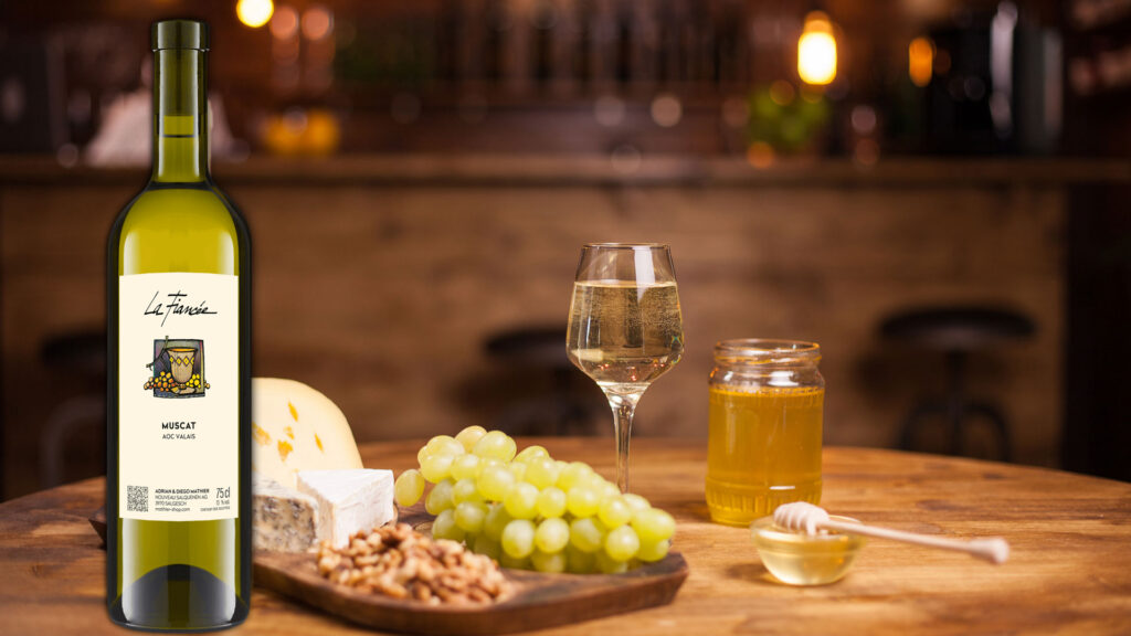 Weinflasche, Weinglas mit Muscat, Trauben, Käse, Honigglas und Honiglöffel auf Holztisch vor unscharfem Hintergrund