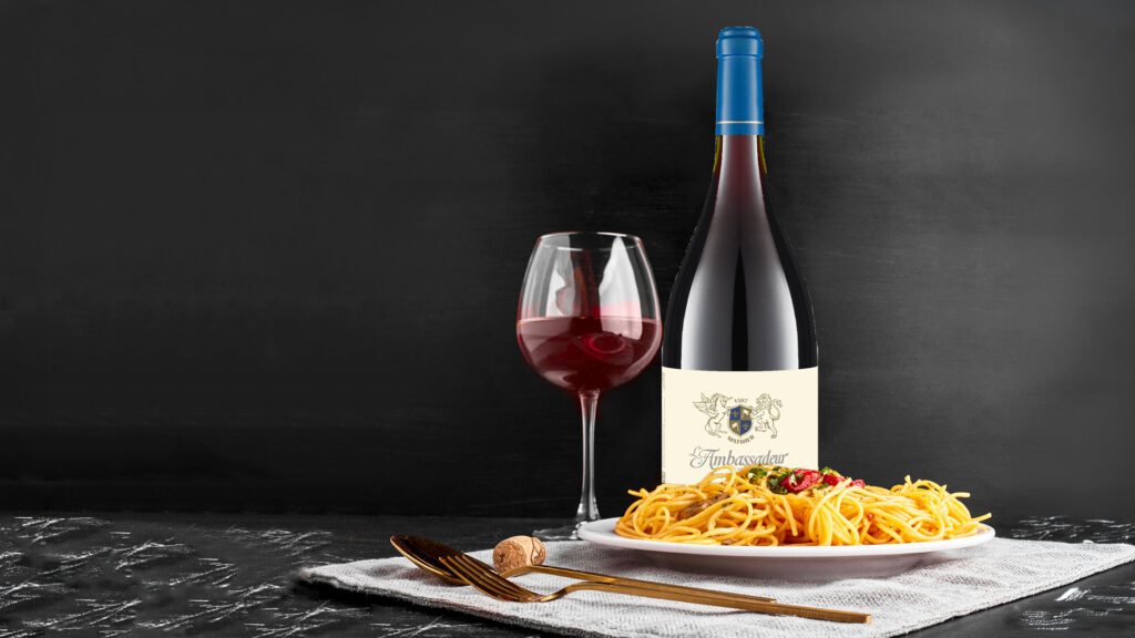 Verre à vin rouge, bouteille de pinot noir et assiette de spaghettis sur toile grise sur fond noir