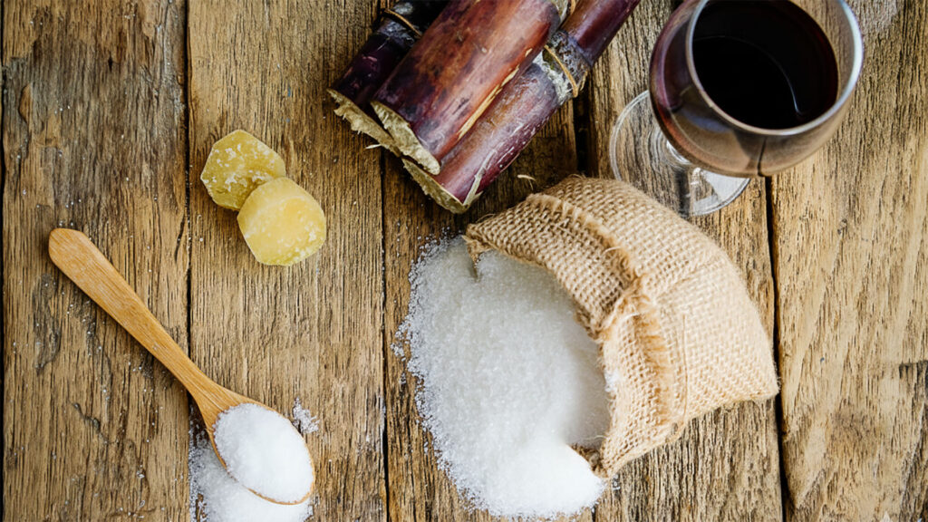 Glas Wein mit Zuckerwürfeln – Zusammenhang von Restsüsse und Zucker im Wein