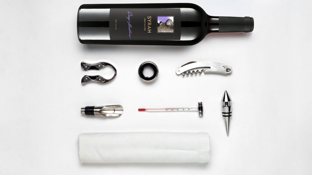 Wine service accessories - corkscrew, decanter and wine utensils on a white table