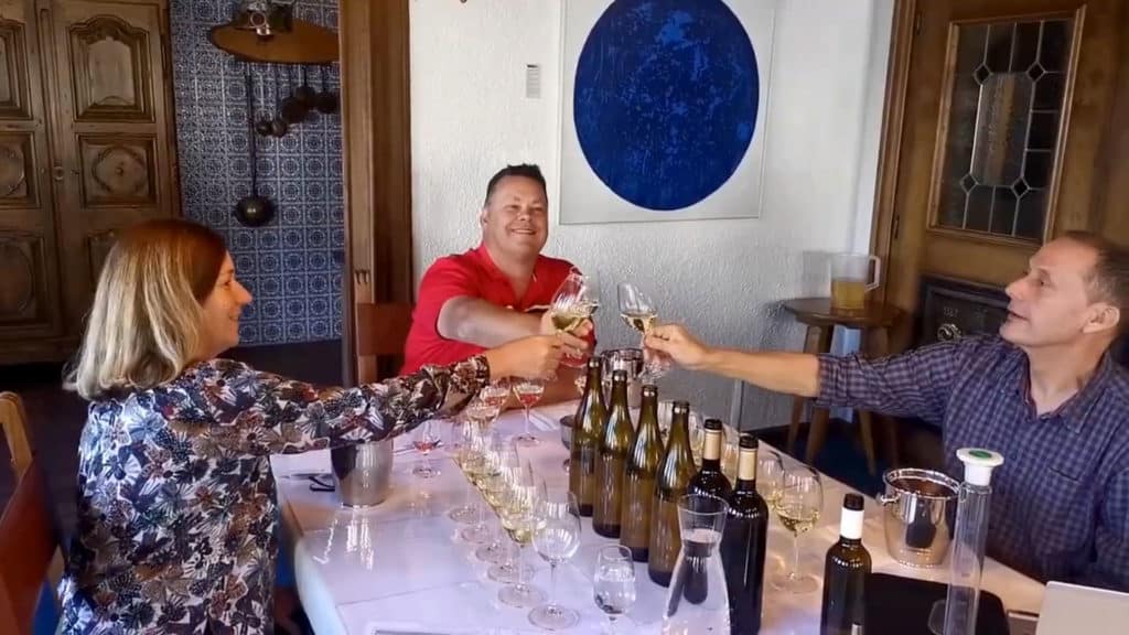 Wein Tasting 66 3 Leute die an einem Tisch mit einem Glas Weisswein anstossen