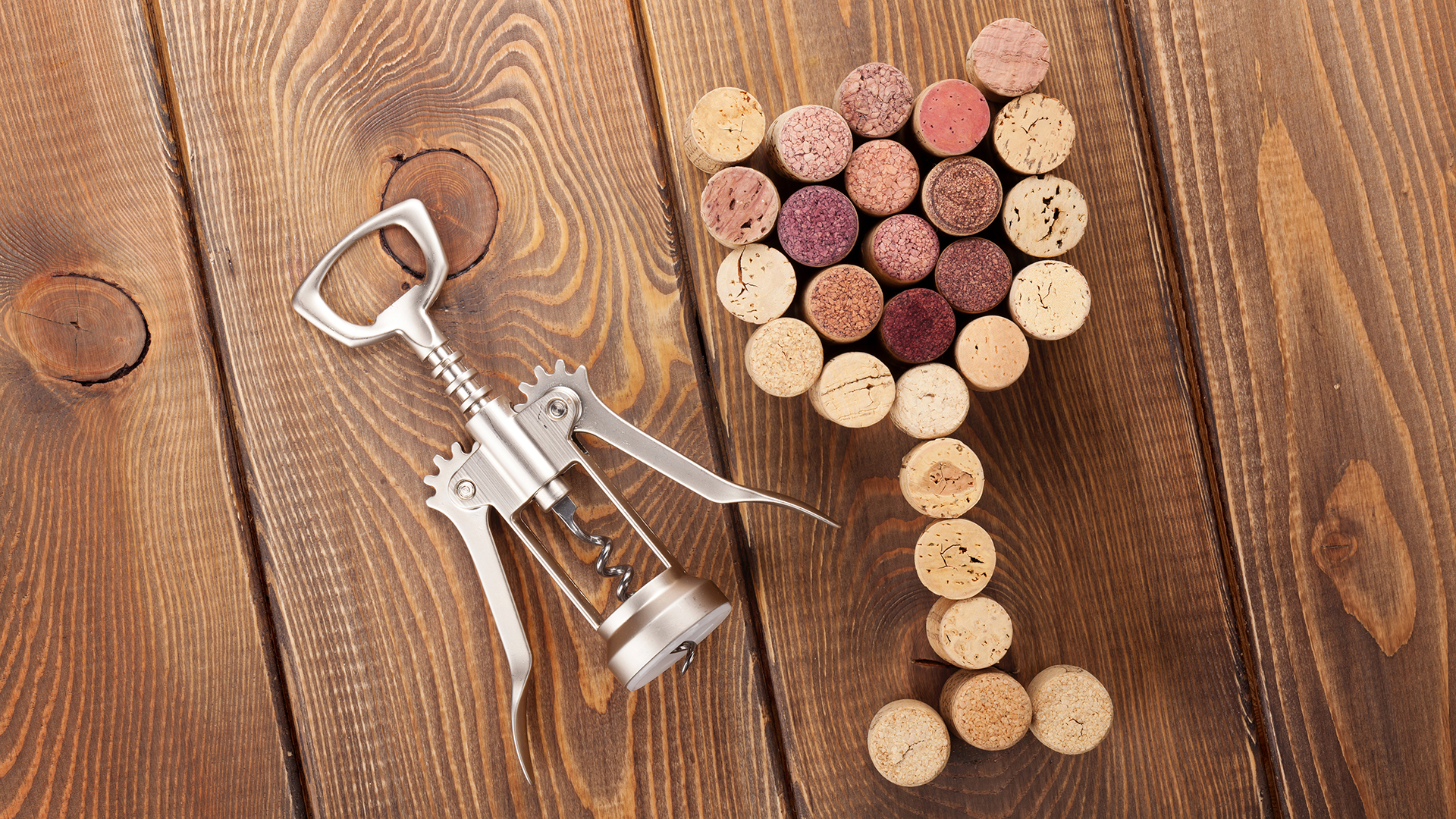Field service gastronomy: cork in the shape of a wine glass and a corkscrew on a wooden surface